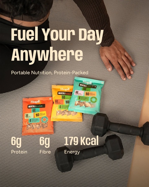 This creative displays muesli packets placed on a workout mat next to dumbbells, using clear text overlays to highlight protein, fibre, and energy content.